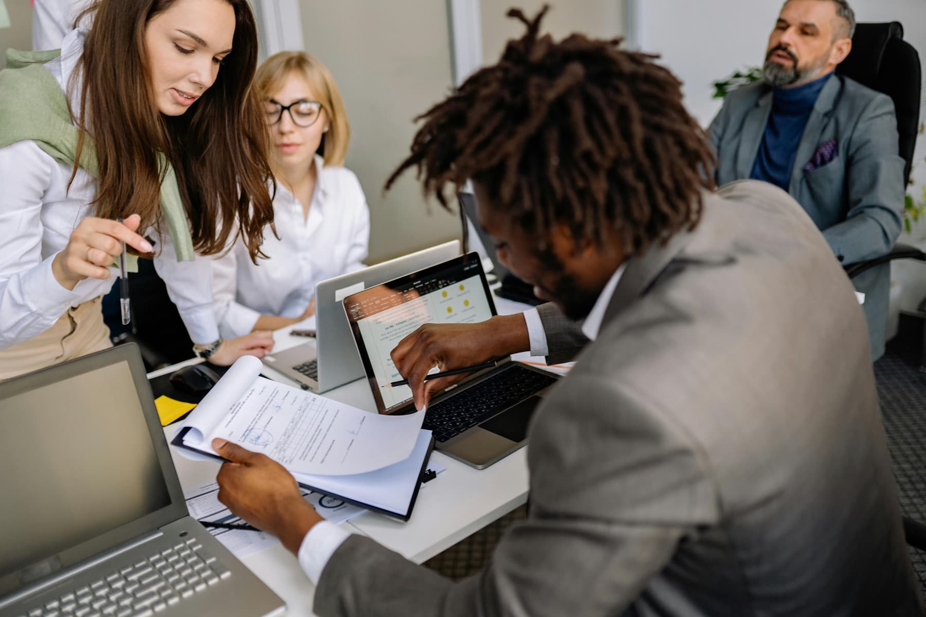 Consulting team reviewing tender documents around a table