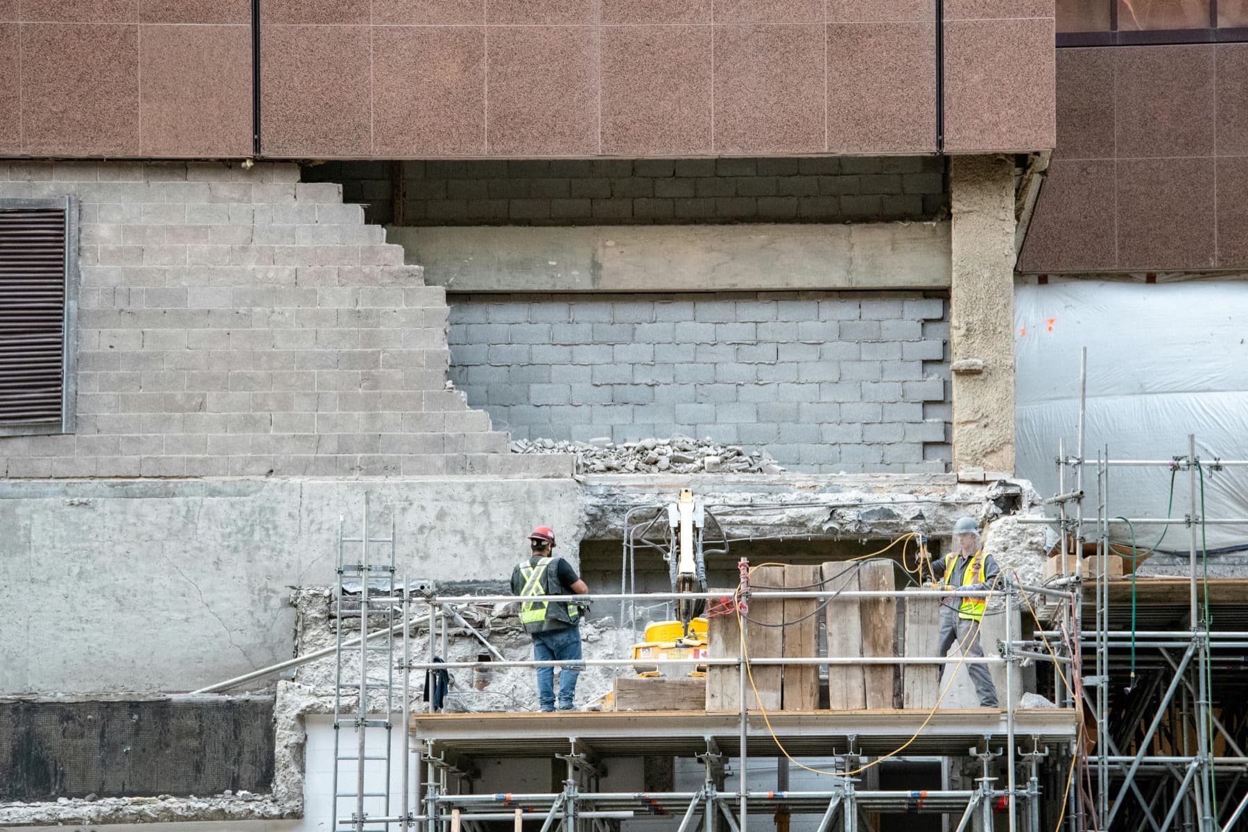 Construction workers on scaffolding at a public works site